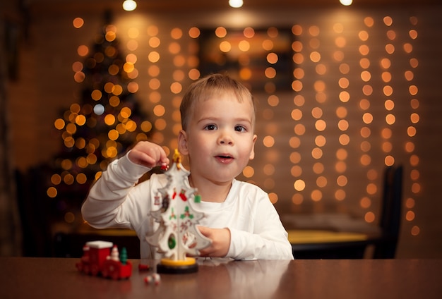 bambino felice il giorno di Natale con il giocattolo dell'albero