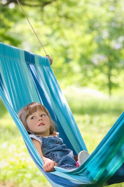 Bambino felice in un'amaca all'aperto nel parco