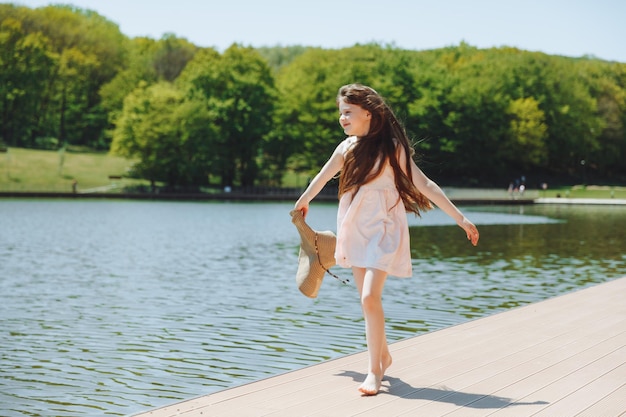 Bambino felice sulla spiaggiala piccola ragazza bionda corre lungo la sabbia sulla spiaggia