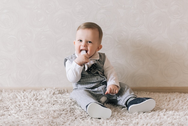 Bambino felice sveglio in vestito elegante da gentiluomo