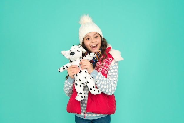 Bambino felice tenere peluche Bambina sorridente con cane giocattolo Sognare un cane vero Negozio o negozio di giocattoli per bambini Stile invernale Divertimento per l'infanzia Faccina sorridente del bambino adorabile Negozio di animali Il suo giocattolo preferito