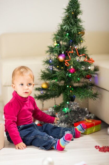 Bambino felice vicino all'albero di Natale