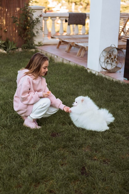 Bambino femminile e cane lanuginoso che giocano