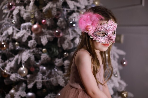 Bambino in abiti eleganti davanti all'albero di Natale. Aspettando il nuovo anno.