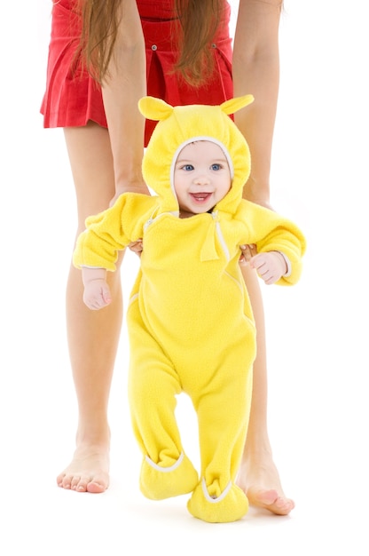 bambino in abito giallo che fa i primi passi