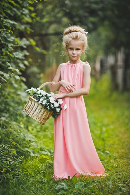 Bambino in abito rosa cammina nel giardino 6586