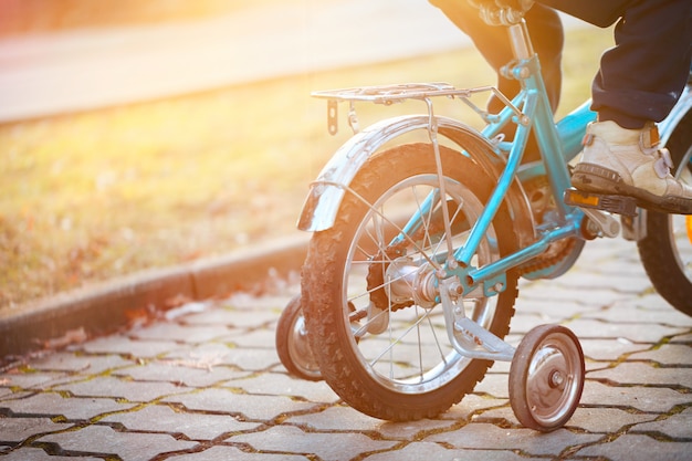 Bambino in bicicletta in una giornata di sole. Vista posteriore.