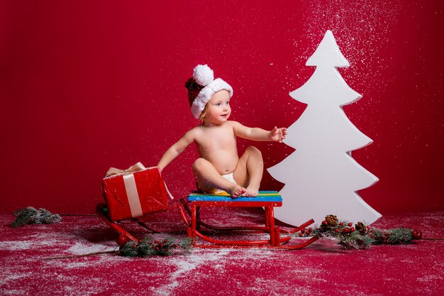 Bambino in cappello della Santa sulla parete rossa