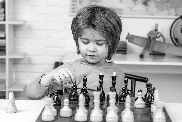Bambino in età prescolare o scolaro che pensa bambino strategia scacchi bambino che gioca a scacchi