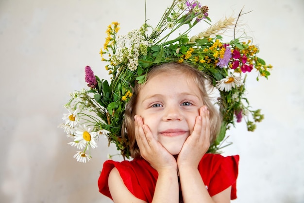 Bambino in ghirlanda di fiori selvatici