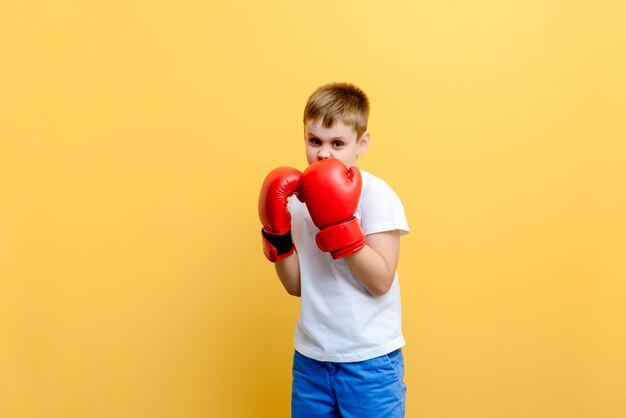 Bambino in guantoni da pugile sul fondo della parete