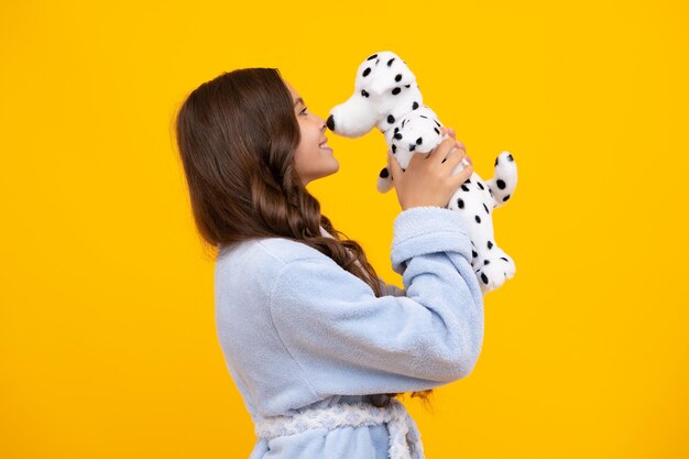 Bambino in pigiama buongiorno Ragazza bambino adolescente in possesso di un peluche isolato su sfondo giallo infanzia felice