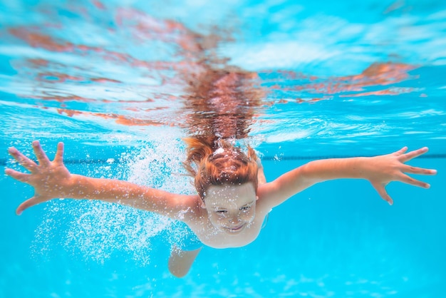 Bambino in piscina nel giorno d'estate giovane ragazzo nuotare e tuffarsi sott'acqua ritratto sott'acqua in piscina chi