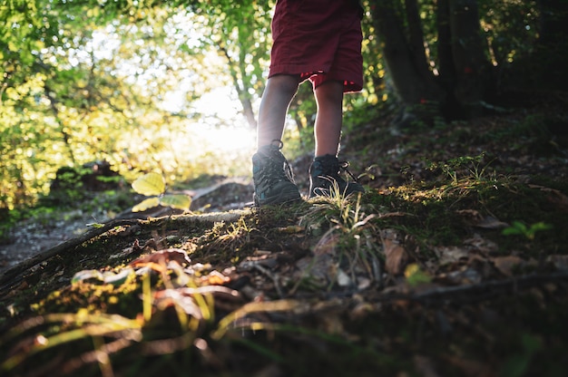 Bambino in scarpe da trekking in piedi sul sentiero