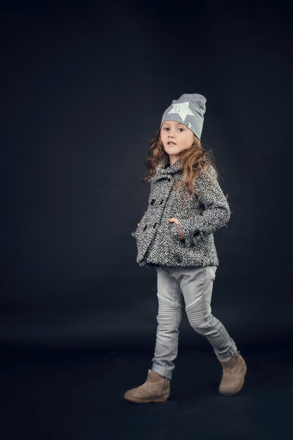 Bambino in studio in posa con abiti alla moda