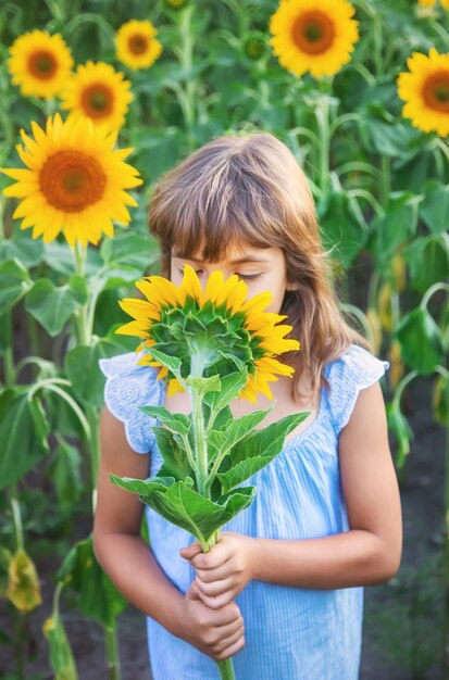 Bambino in un campo di girasoli in fiore