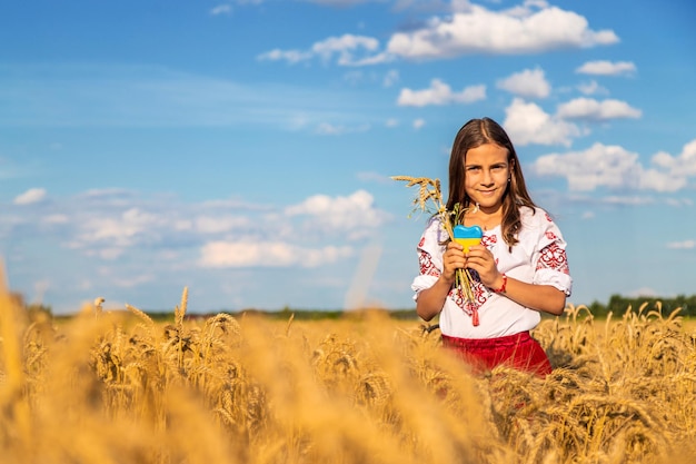 Bambino in un campo di grano con la bandiera dell'Ucraina Messa a fuoco selettiva Natura