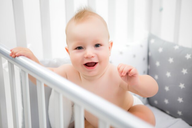 bambino in un lettino per bambini su uno sfondo chiaro