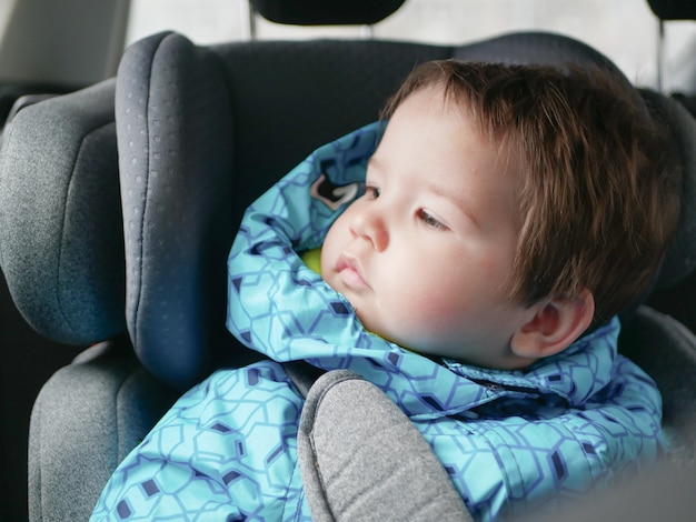 Bambino in un seggiolino per auto. Sicurezza dei bambini nel seggiolino auto durante il sonno.