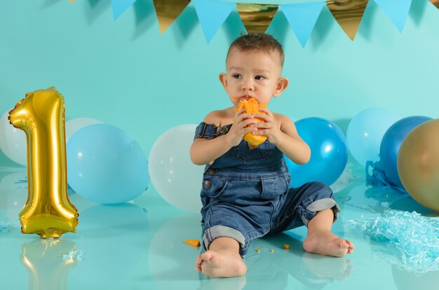 Bambino in una sessione fotografica che mangia mango