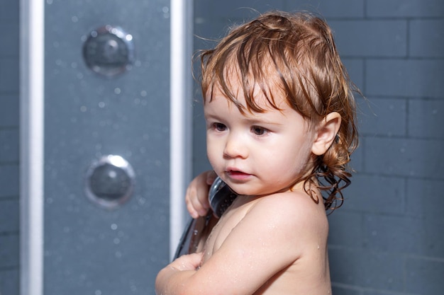 Bambino in una vasca da bagno che fa il bagno bambino felice con schiuma di sapone sulla testa