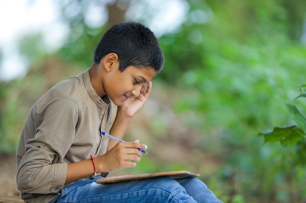 Bambino indiano che scrive sul taccuino