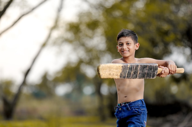 Bambino indiano rurale che gioca cricket