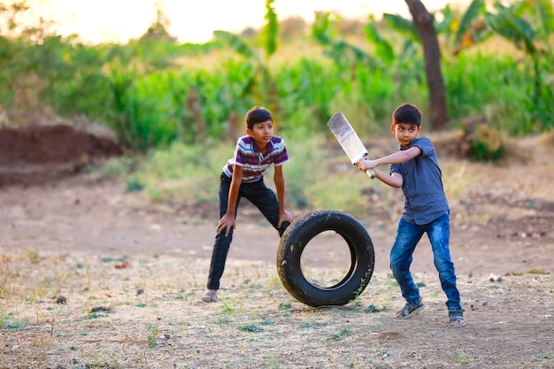 Bambino indiano rurale che gioca cricket