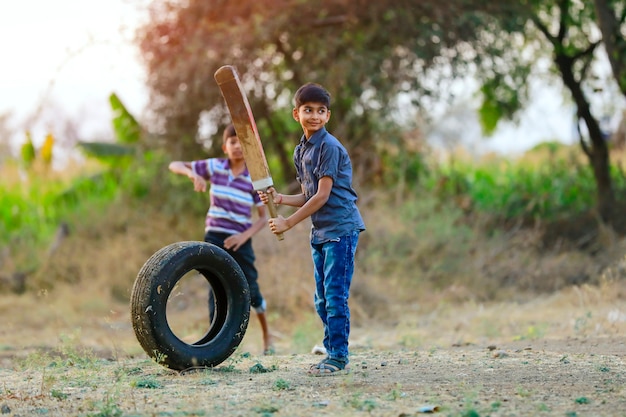 Bambino indiano rurale che gioca cricket