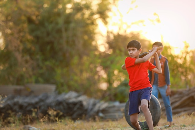 Bambino indiano rurale che gioca cricket