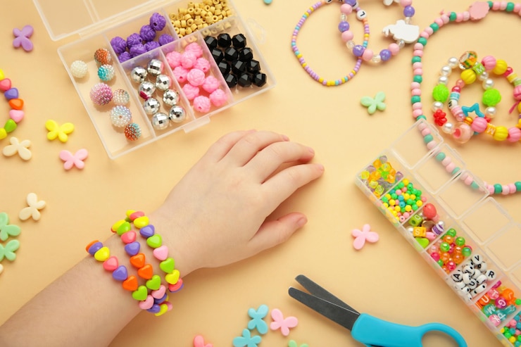 Bambino indossa braccialetti sulle mani Bambini gioielli a perle fatti a mano su sfondo beige
