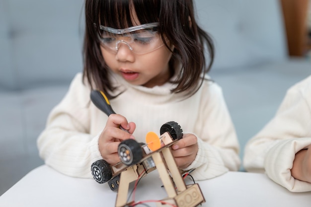 Bambino inventivo che costruisce auto robot a casa