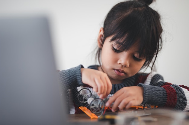 Bambino inventivo che costruisce auto robot a casa