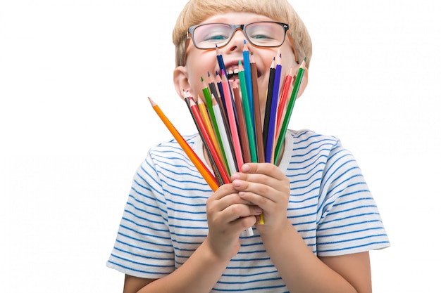 Bambino isolato con matite. Adorabile bambino su sfondo bianco. Ritratto di ragazzo biondo divertente con matite colorate.