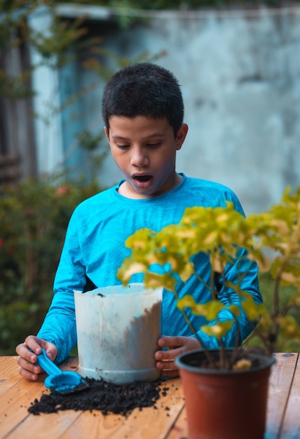 Bambino latino preoccupato perché ho sparso la terra sul tavolo