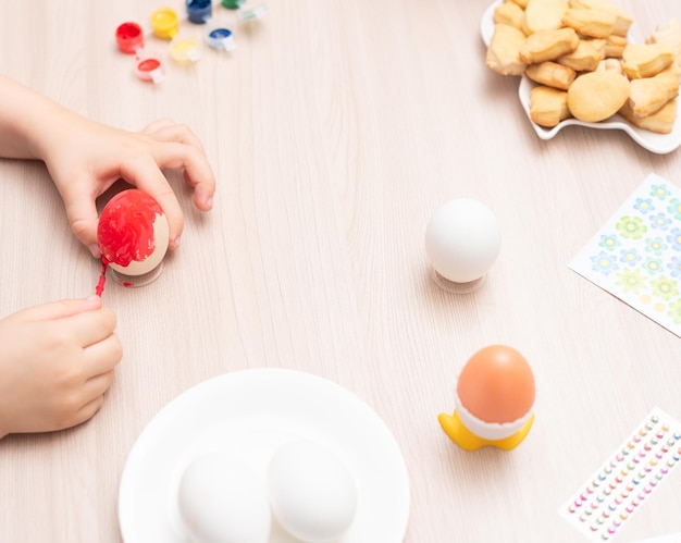 Bambino mani pittura fuoco selettivo uova di Pasqua Buona Pasqua concetto Processo di lavorazione a casa Biglietto di auguri con spazio di copia