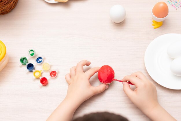 Bambino mani pittura fuoco selettivo uova di Pasqua Buona Pasqua concetto Processo di lavorazione a casa Biglietto di auguri con spazio di copia