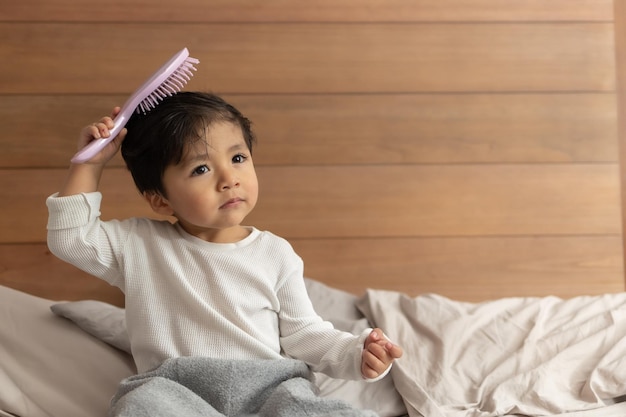 Bambino messicano che si pettina dopo la doccia in camera da letto