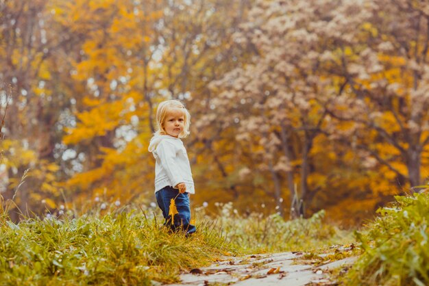 Bambino nel parco d'autunno