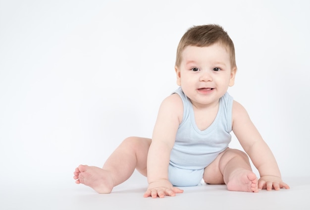 Bambino neonato seduto felice sorridente ragazzo su uno sfondo bianco 7 mesi