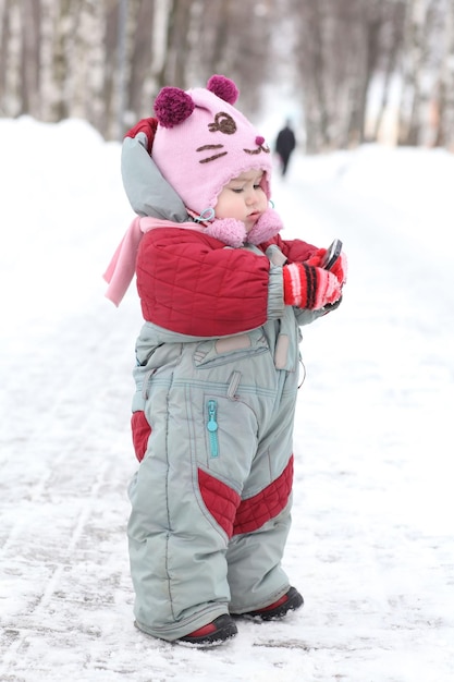 bambino per una passeggiata in inverno con una telefonata