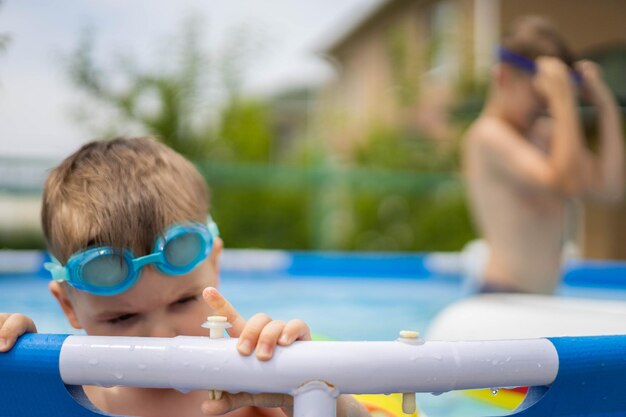 Bambino piccolo ragazzo in piscina con cerchi luminosi di nuoto