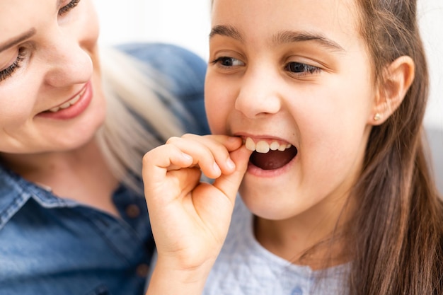 Bambino piccolo sveglio che tiene il suo dente che può essere allentato o dolorante.