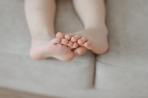 Bambino piedi nudi primo piano all'interno bambino seduto a piedi nudi