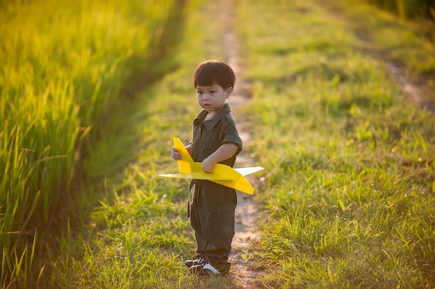 bambino pilota aviatore con aereo sogna di viaggiare nella natura al tramonto