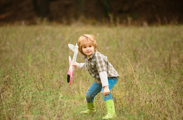 Bambino pilota con aereo giocattolo sogna di viaggiare in estate in natura bambini sogna bambino divertirsi