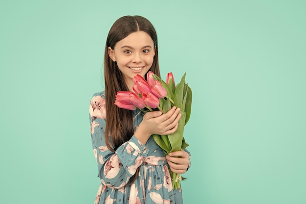 Bambino positivo con tulipani madri o festa della donna bambino tenere fiori per l'8 marzo