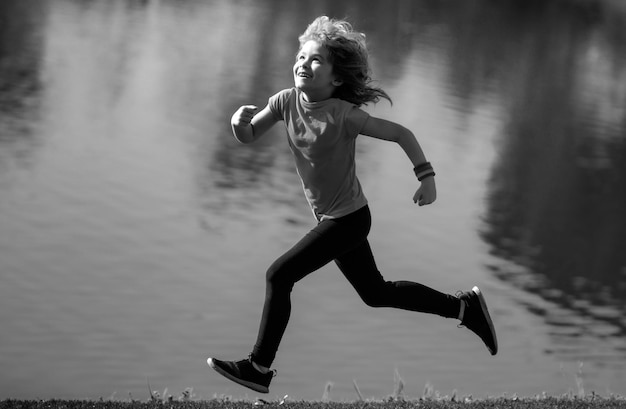 Bambino ragazzo che corre all'aperto bambino che corre in un parco estivo sport all'aria aperta e fitness per bambini