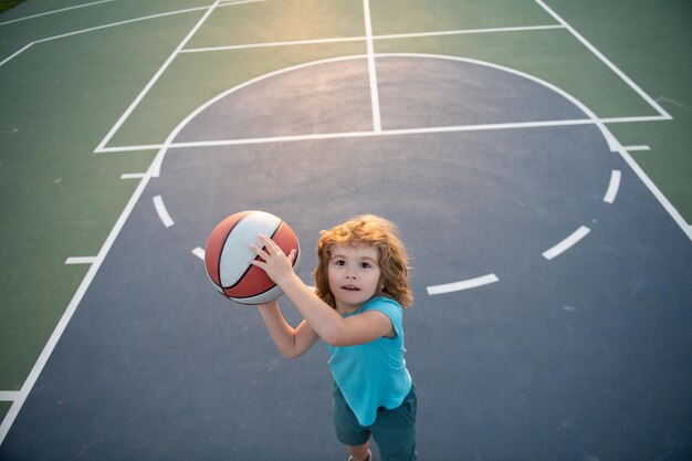 Bambino ragazzo che si prepara per le riprese di basket Palla da basket per bambini