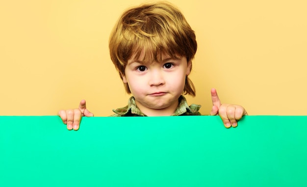 Bambino ragazzo con cartellone vuoto ragazzino con cartello bianco pubblicità di beni per bambini